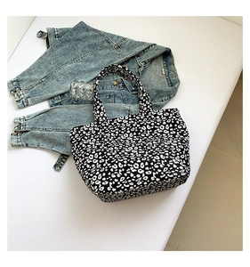 Flat lay of black and white leopard print canvas tote bag with casual denim jacket