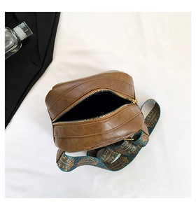 Detailansicht der braunen PU-Ledertasche mit farbigem Ethno-Gurt und offenem Innenfach