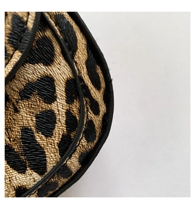 Macro view of leopard print leather texture and refined black edge stitching details