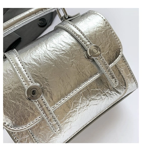 Detailed macro view of silver metallic messenger bag with textured crinkle finish