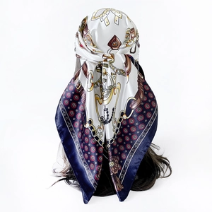 Close-up of classic chain print satin scarf worn as an elegant headscarf on a model