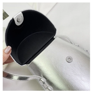 Macro shot of silver metallic saddle bag featuring double magnetic snap button closure