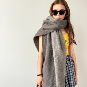 Close-up of a soft dark grey mohair shawl showing fluffy texture and premium knit detail