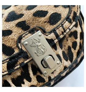 Detail of leopard print handbag featuring a silver stag logo twist lock closure