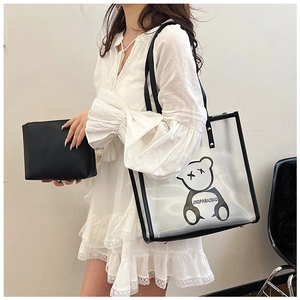 Waterproof transparent tote bag with black handle and inner pouch held by model