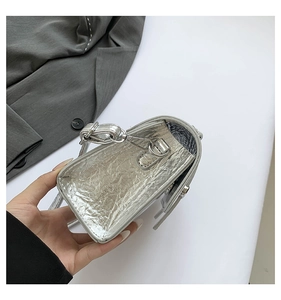 Detail showing the silver metallic crinkle texture and metal ring on the side of this bag