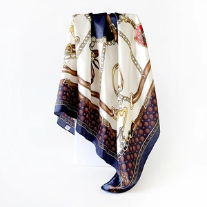 Detail of elegant navy satin square scarf with classic gold chain and equestrian print