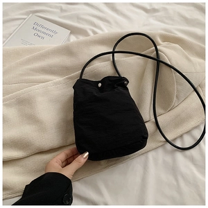 Minimalist black nylon crossbody phone bag with metal snap button and drawstring strap