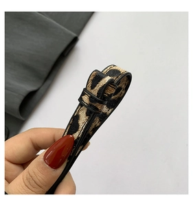 Detail view of the leopard print leather strap with smooth black edge paint finish