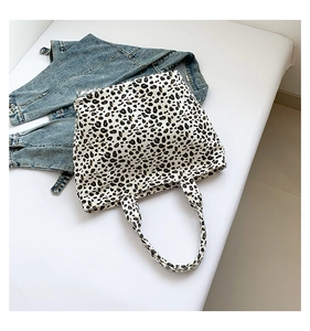 Detailed top view of a leopard print canvas tote bag styled with a blue denim jacket
