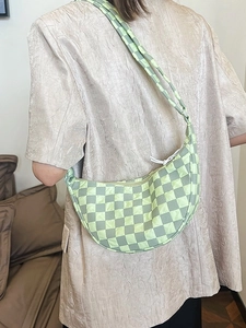 Borsa a tracolla trapuntata a scacchi verde e gialla a forma di mezzaluna indossata