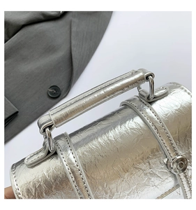 Detail of silver metallic crackle texture messenger bag with sleek handle and hardware