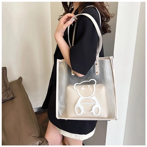 Detailed view of the clear PVC bear tote bag with inner pouch worn by a model