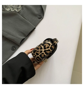 Detail of leopard print mini bag featuring black leather trim and metal twist lock