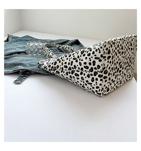 Detail of leopard print tote bag with soft texture paired with a denim jacket