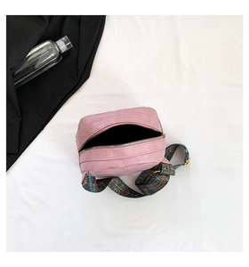 Detailansicht der rosa PU-Umhängetasche mit breitem Ethno-Muster-Stoffschultergurt