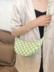 Borsa a tracolla a mezzaluna a scacchi verde chiaro indossata da una modella