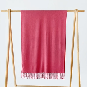 Detailed view of rose pink cashmere-like scarf with soft texture and long fringe tassels