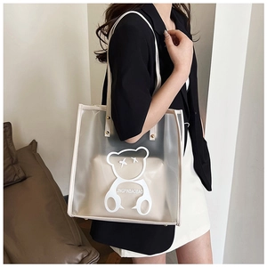 Detail of transparent PVC tote bag with cartoon bear print and beige inner pouch
