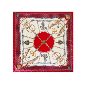 Detail of red square silk scarf with vintage equestrian golden chain and buckle patterns