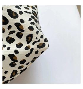 Detailed close-up showing the leopard print pattern and heavy twill canvas texture of the bag