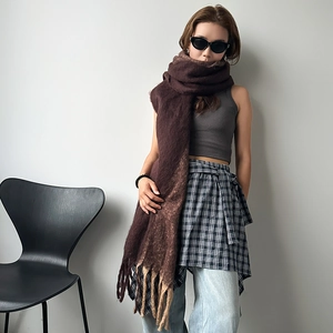 Deep burgundy mohair scarf with long tassels styled in a minimalist fashion setting