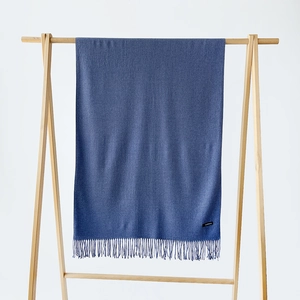 Detailed close-up of blue cashmere scarf fabric texture and elegant tassel edges