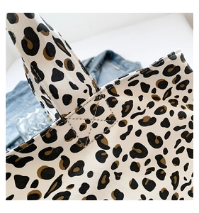 Close-up of leopard print canvas tote bag with reinforced cross-stitching detail