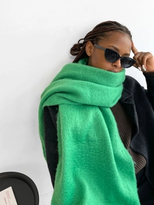 Close-up of vibrant green mohair scarf showing thick knit texture and fringe detail