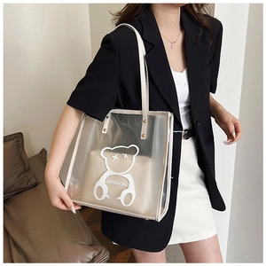 Transparent PVC tote bag with white bear print and inner pouch shown on a model