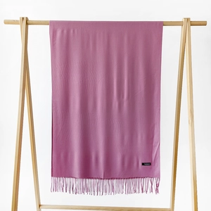 Detailed close-up of dark pink cashmere scarf with soft fringe and fabric label