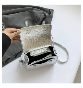 Detail view of silver metallic messenger bag with inner zipper pocket and magnetic closure