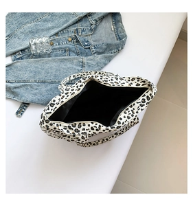 Flat lay of leopard print canvas tote bag with denim jacket and black fabric lining details