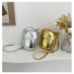 Detailed view of glossy gold and silver saddle bags with textured metallic finish