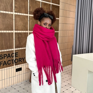 Detailed view of magenta mohair scarf featuring thick knit texture and long tassels