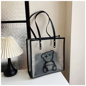 Macro detail of clear waterproof tote bag with black bear print and leather handles