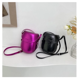 Detail of mini saddle bags in metallic fuchsia and glossy black leather finishes