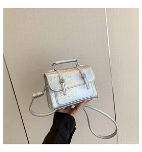 Close-up of holographic silver mini bag featuring textured wrinkles and metal studs