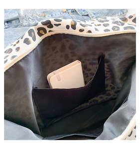 Detail of leopard print tote bag interior featuring an open pocket for organization