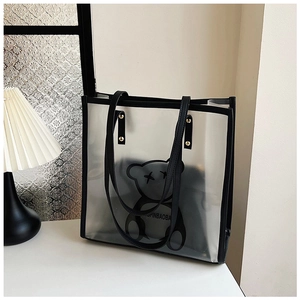Detailed view of clear PVC tote with bear print and black leather inner pouch