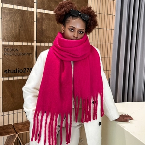 Detailed texture of thick mohair scarf in vibrant rose pink with soft fringe edges