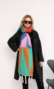 Detail van geometrische mohair sjaal met kleurrijke blokken en dikke gedraaide franjes