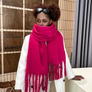 Detail of soft rose red mohair scarf with thick tassels styled with a white coat
