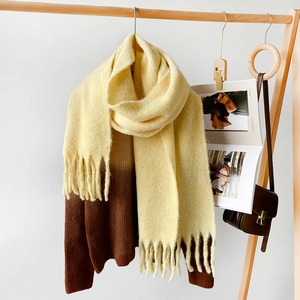 Detail of a thick mohair scarf with tassels paired with a brown gradient sweater