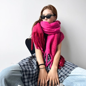 Detail of rose red mohair scarf showing thick long tassels and fluffy knit texture