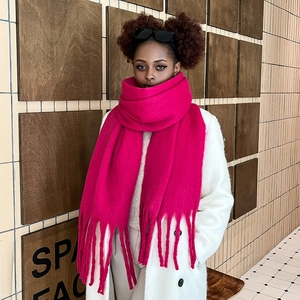 Detail shot of soft rose red mohair scarf featuring long tassel fringe and thick knit texture