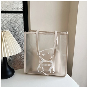 Detail of waterproof semi-transparent frosted PVC tote bag with cute bear and beige leather handles