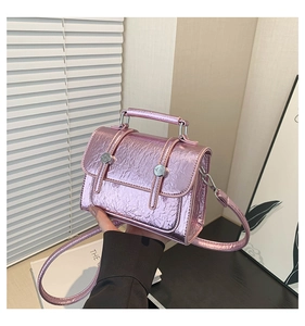 Detail showing pink metallic crackle leather messenger bag with silver buckles and handle