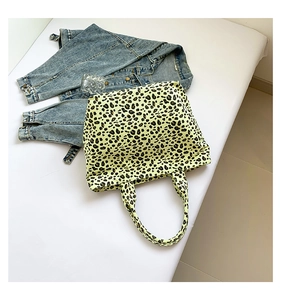 Detail of yellow leopard print canvas tote bag with retro patterns on white background