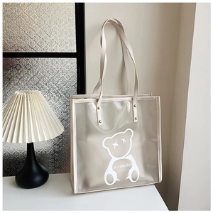 Detail of transparent waterproof tote bag with bear print and sturdy beige handles